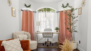 A room with a desk, chair, and a couch. There is a window with curtains, a lamp, and a plant. - Sleeps 10 - Sparkling Pool - 7 mins to DT Chandler (Chandler)