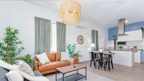A modern living room with a sofa, coffee table, and dining area. - Apt B, Sunny San Juan Getaway (San Juan)