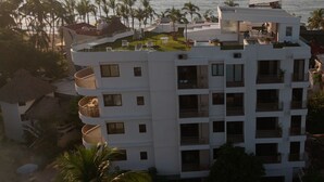A multi-story hotel with balconies, a rooftop garden, and a view of the sea. - La Esquina - Solana Penthouse Suite (San Francisco)