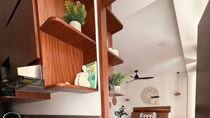 A modern kitchen with a built-in stove, wooden shelves, and a dining area with a table and chairs. - La Esquina - Solana Penthouse Suite (San Francisco)