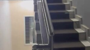 Eine Treppe mit Metallgeländer, die zu einer Empore führt.