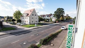 A street view with a building labeled "PENSION" and a row of parked cars. - Pension Greiser: Affordable accommodation in Leipzig (Leipzig)