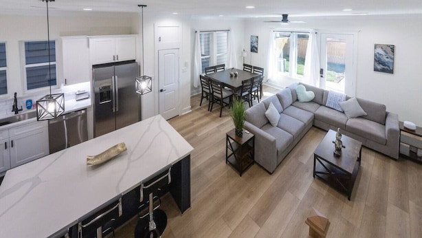 A spacious living area with a large sofa, dining table, and kitchen area with modern appliances.