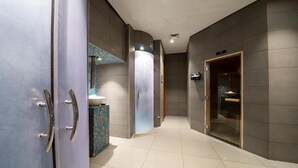 A modern hallway with a glass door leading to a bathroom, a tiled floor, and a wall-mounted light fixture. - DAMAC Super Luxury Two Bedroom Apartment (Riyadh)