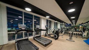 A modern gym with treadmills, elliptical machines, and weight equipment. - DAMAC Super Luxury Two Bedroom Apartment (Riyadh)