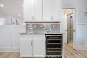 A kitchen with white cabinets, a stainless steel oven, and a tiled backsplash. - Beach Oasis Sleeps 26 Walk to Beach and Private Pool (North Myrtle Beach)