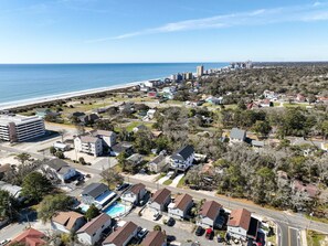 A coastal residential area with houses, a parking lot, and a view of the ocean. - Beach Oasis Sleeps 26 Walk to Beach and Private Pool (North Myrtle Beach)
