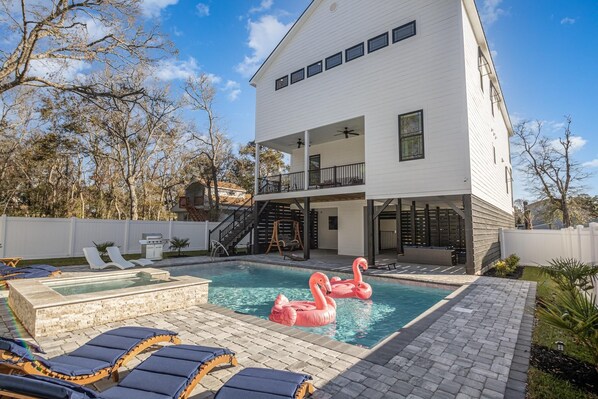A modern two-story house with a swimming pool, lounge chairs, and a hot tub. - Beach Oasis Sleeps 26 Walk to Beach and Private Pool (North Myrtle Beach)