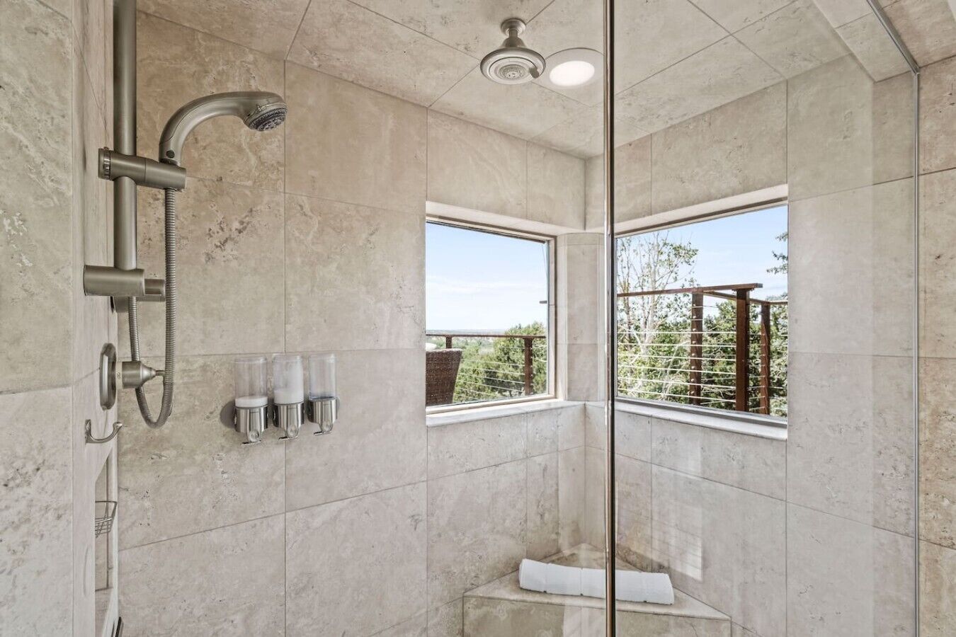 Uma casa de banho moderna com chuveiro, janela e suporte para toalhas.
