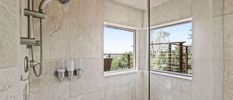 Une salle de bain moderne équipée d’une douche, d’une fenêtre et d’un porte-serviettes.