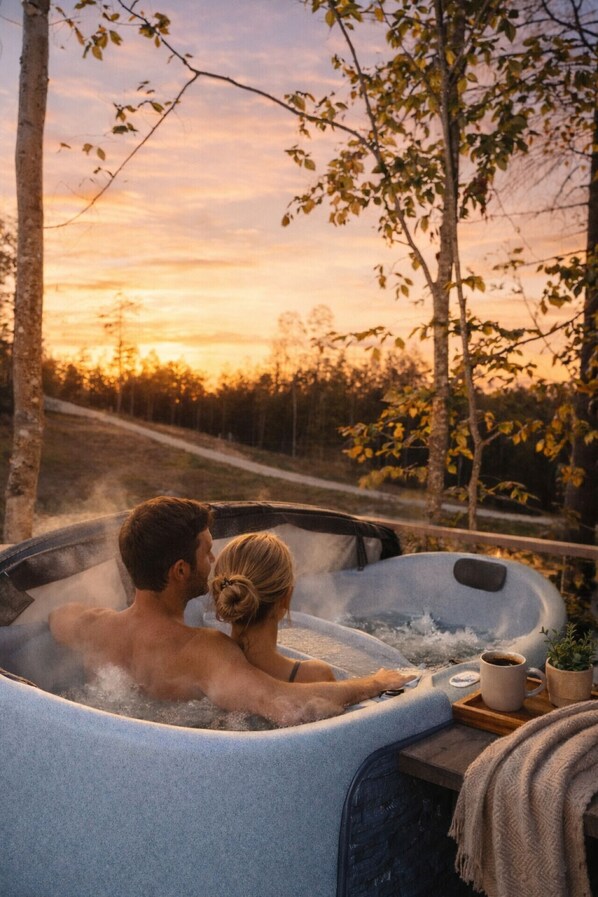 Ein Paar entspannt in einer Whirlpool mit Blick auf den Sonnenuntergang.