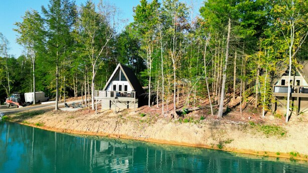 Una casa junto al lago con un bote amarrado al frente.