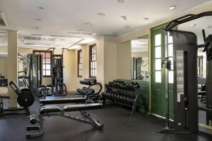 Een sportschool met gewichthefapparatuur, dumbbells en cardioapparaten.