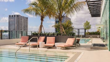 Een buitenzwembad, parasols voor strand/zwembad