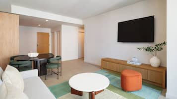 Deluxe suite, 1 kingsize bed met slaapbank, balkon | Woonruimte | Een 65-inch flatscreentelevisie met kabelzenders