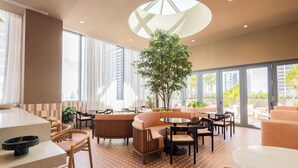Ein modernes Interieur mit einer zentralen Sitzecke, großen Fenstern und einem Oberlicht.