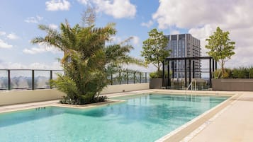 Alberca al aire libre, sombrillas en la alberca y camastros