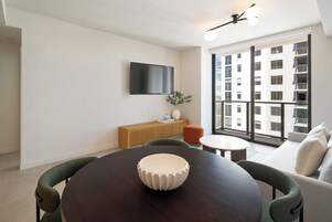 Suite Deluxe, 1 cama de matrimonio grande con sofá cama, balcón | Zona de estar | Televisión de pantalla plana de 65 pulgadas con canales por cable