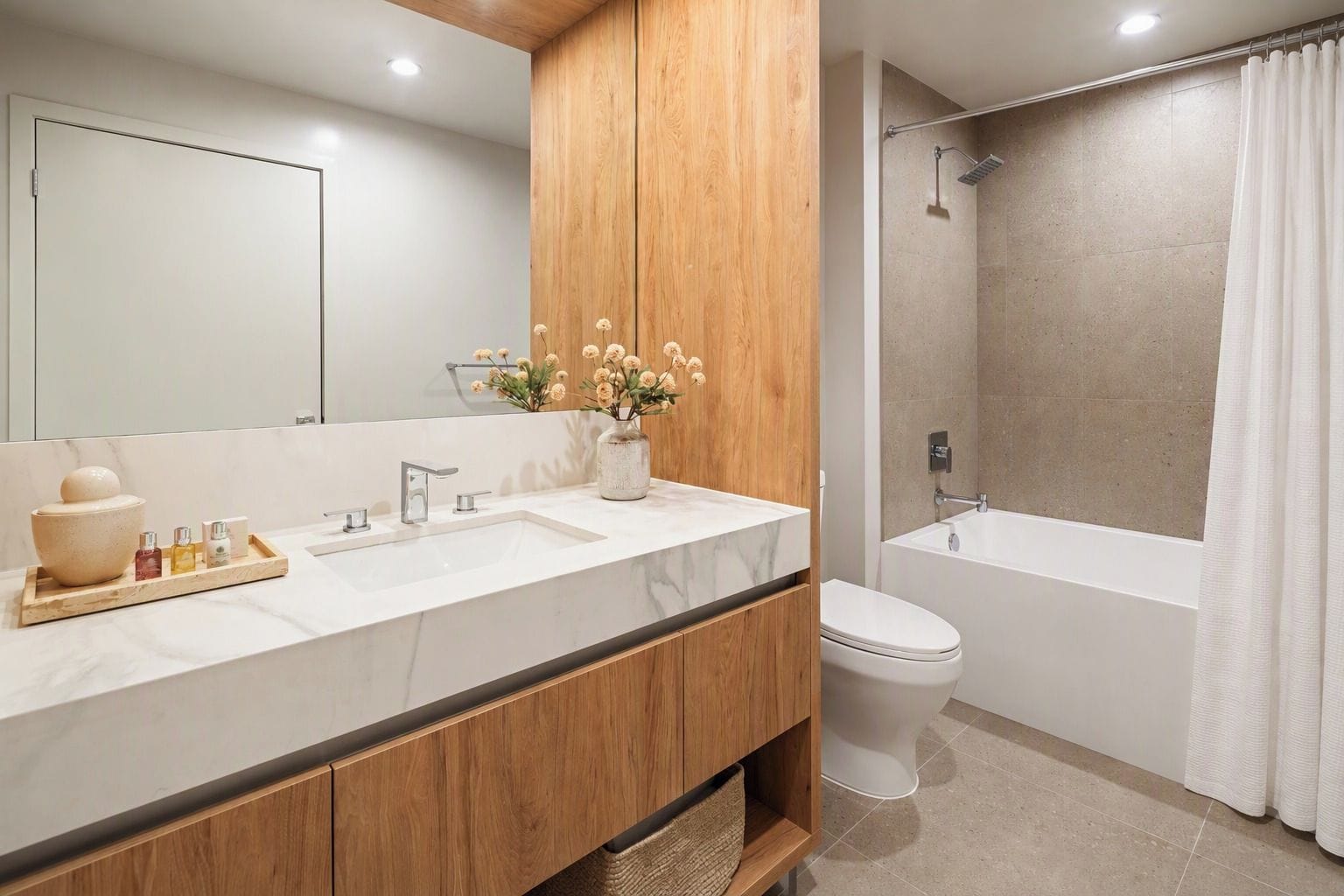 Een moderne badkamer met een houten wastafelmeubel, een grote spiegel, een wastafel, een toilet en een douchehoek.