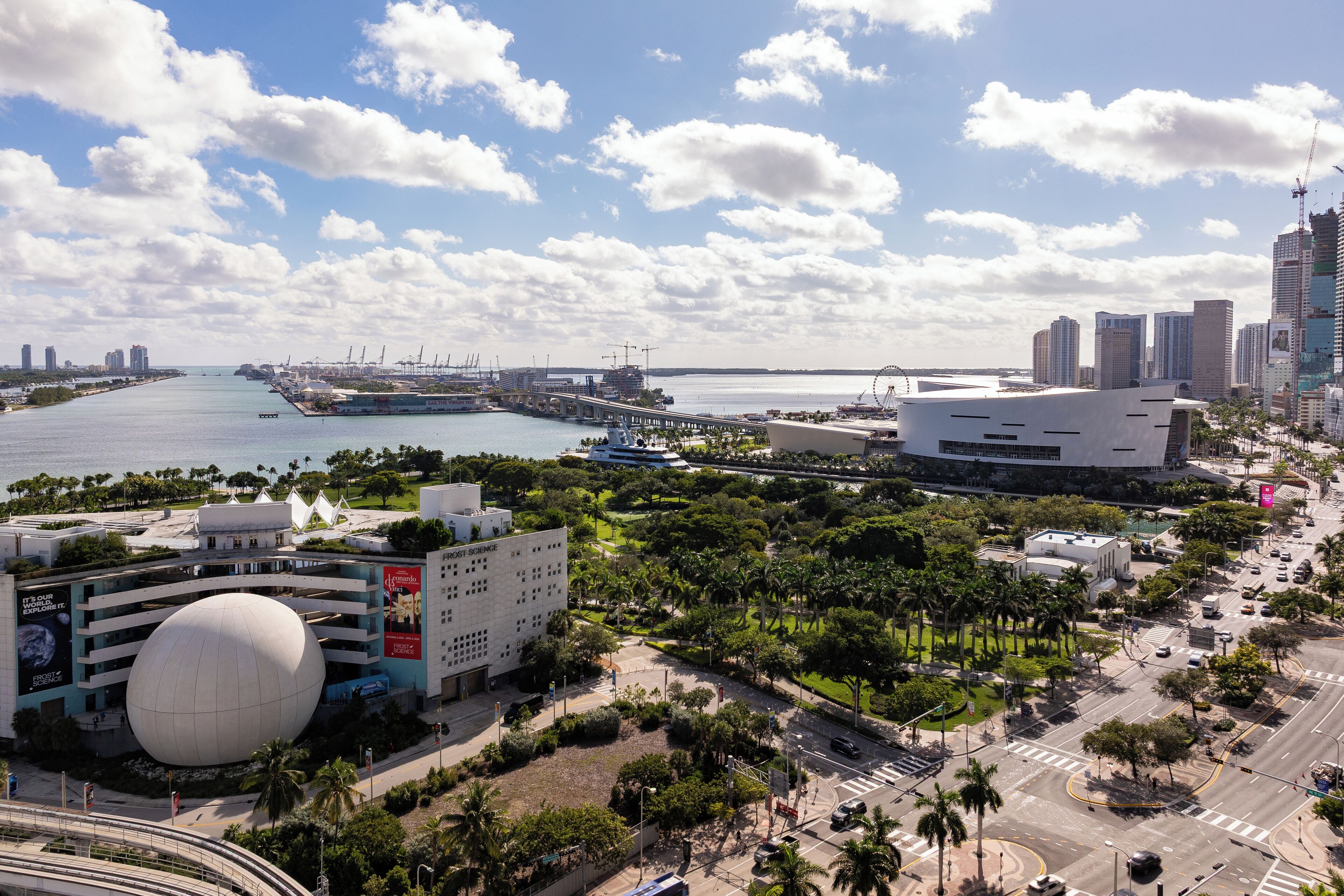 A cityscape with modern architecture, a waterfront, and a large spherical building.
