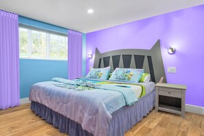 A bedroom with a bed, curtains, a nightstand, and a window.