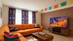 Ein modernes Wohnzimmer mit Sofa, Couchtisch und Fernseher.