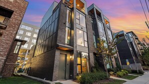 Un edificio moderno de varios pisos con amplios ventanales y fachada de ladrillo.