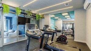 Una palestra moderna con tapis roulant, cyclette e attrezzature per l'allenamento con i pesi.