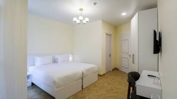 Un dormitorio con cama doble, escritorio, silla, armario y lámpara de techo.