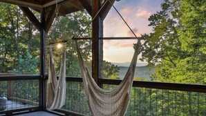 A hammock on a wooden deck with a view of a forest and mountains. - Pop`s Peak| Morganton, GA (Morganton)
