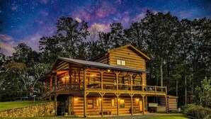 A two-story log cabin with a balcony, surrounded by trees and a starry sky. - Pop`s Peak| Morganton, GA (Morganton)