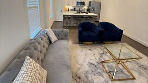 A modern living room with a grey sofa, two blue armchairs, and a marble coffee table. - Cozy & Luxury 3BR for Families, Nurses & Groups (Houston)
