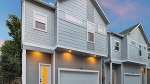 A modern two-story house with a garage, multiple windows, and a well-lit exterior. - Cozy & Luxury 3BR for Families, Nurses & Groups (Houston)