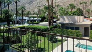A resort with a pool, palm trees, and a mountain backdrop. - 2-bedroom condo in Historic Tennis Club (Palm Springs)