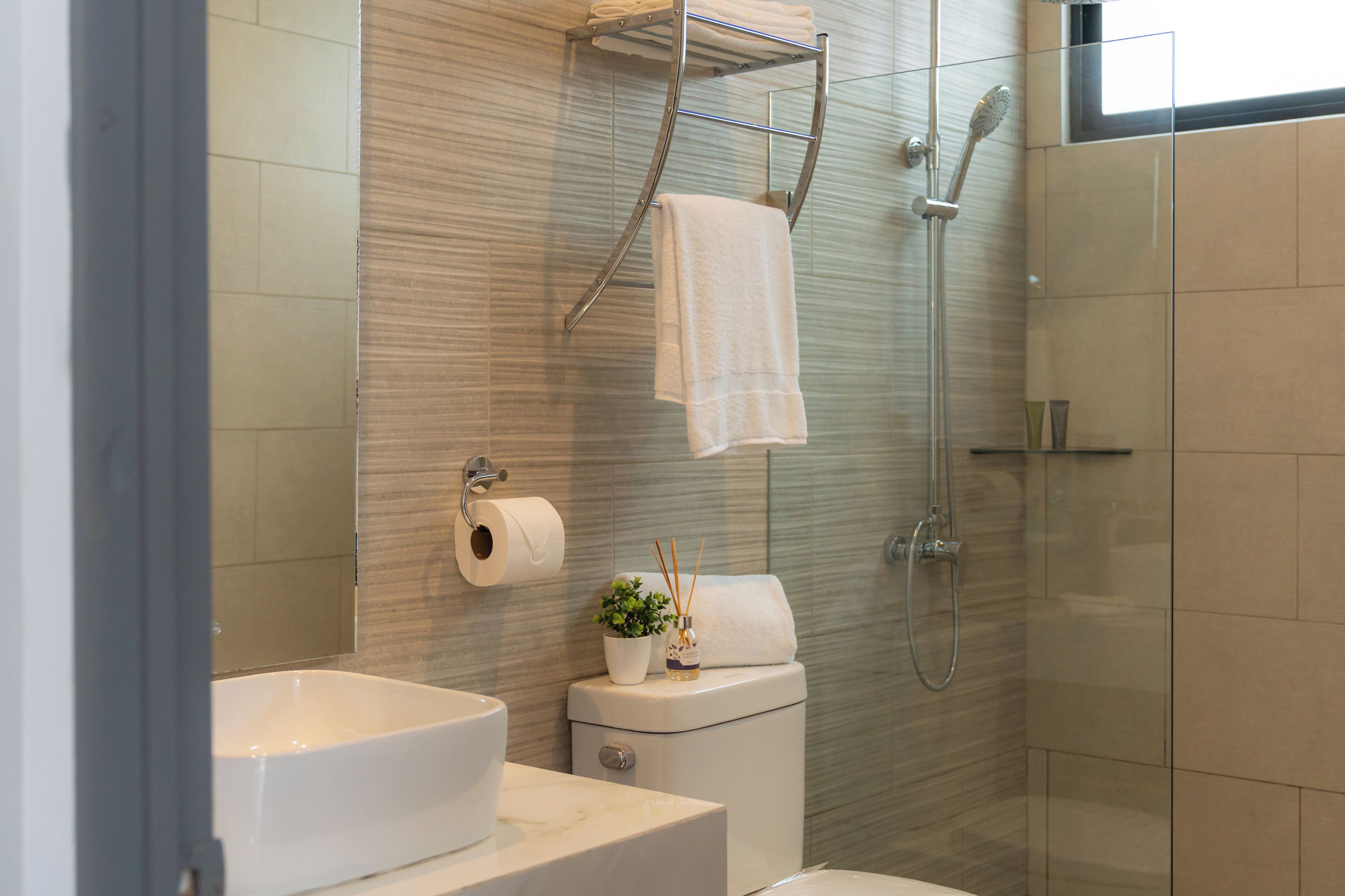 Une salle de bain moderne avec une douche à parois de verre, un lavabo blanc et des toilettes.