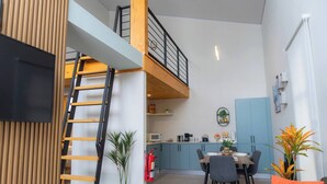 A modern apartment with a loft-style living area, a dining space, and a kitchen. - Sakura Haus (Turrialba)