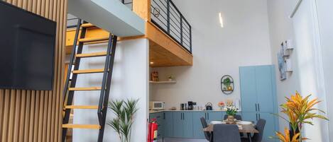 Un apartamento moderno con una zona de estar tipo loft, un comedor y una cocina.