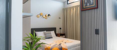 Un dormitorio moderno con cama, mesita de noche, lámpara y decoración mural.