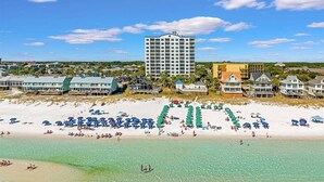 Un hôtel situé sur la côte, avec accès direct à la plage, plusieurs piscines et un grand bâtiment en arrière-plan.