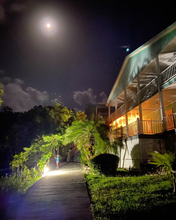 A pathway leading to a building with a balcony and stairs.