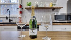 A bottle of André California Champagne on a kitchen counter with two empty wine glasses. - Pocono Retreat 4BR, Hot Tub,Game Room,  (Long Pond)