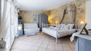 Une chambre à coucher avec un lit, une armoire, un bureau et une fenêtre avec des rideaux.