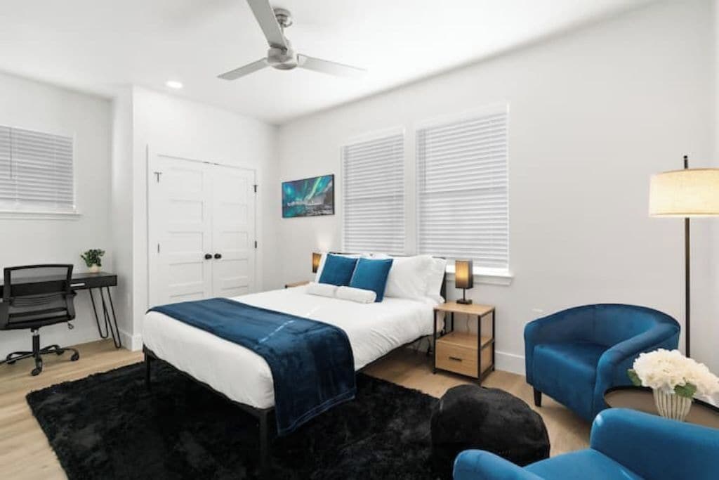 Ein Schlafzimmer mit einem Bett, einem Schreibtisch, einem Stuhl und einer Lampe.