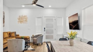 Un salon moderne avec un canapé, un fauteuil et une table à manger.