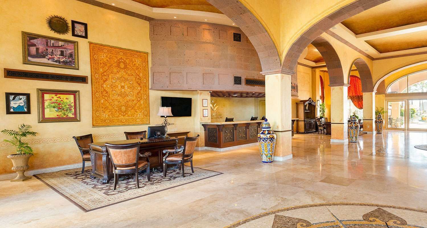 A spacious lobby with a high ceiling, a fireplace, and a dining area with a large rug.