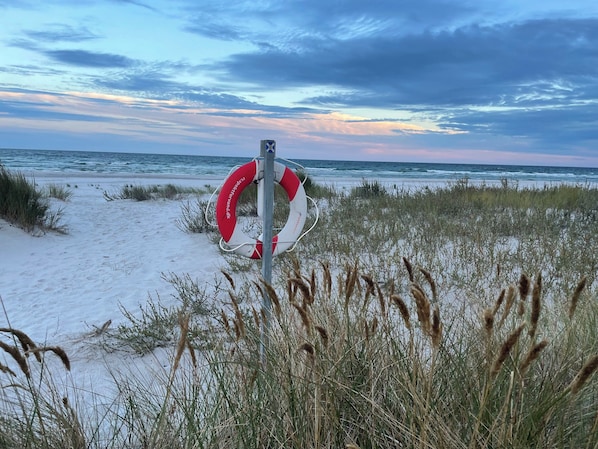 Ein Rettungsring an einem Pfahl am Strand.