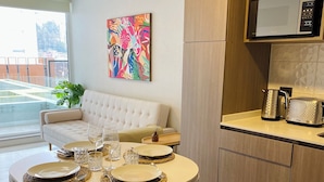 Una cocina moderna con microondas, tostadora y hervidor sobre la encimera.