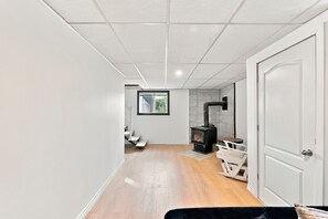 A modern interior with a wood-burning stove, a staircase, and a door. - 5 minutes from Mont-Garceau! Water House with Spa in Saint-Donat. (Saint-Donat)