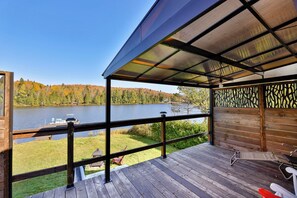 A wooden deck with a view of a lake and forest.