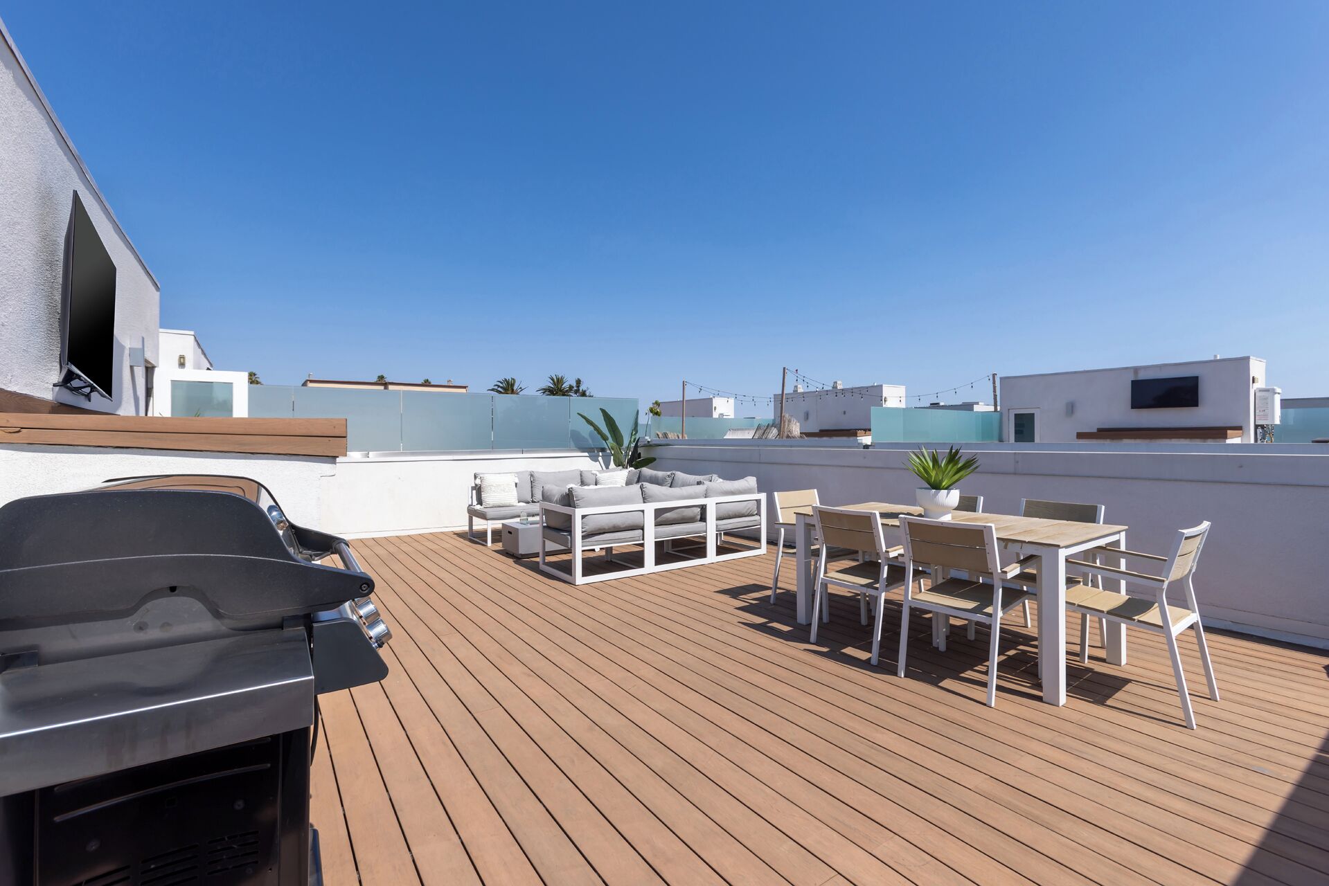 Terraço no telhado com churrasqueira, área de estar e vista para a cidade.